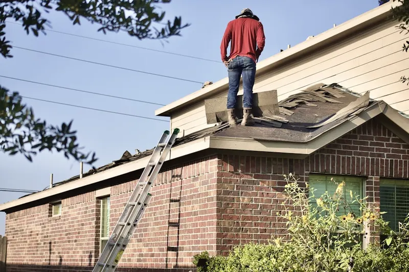 Professional roofer working on a residential roof in Frontenac